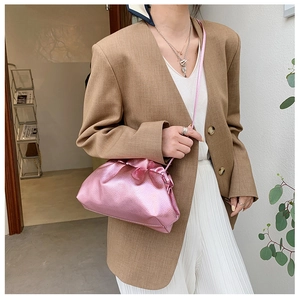 Gros plan d'un sac nuage plissé rose en cuir brillant avec fine bandoulière réglable