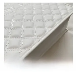 Gros plan du motif matelassé en losange et des coutures sur un sac cabas blanc
