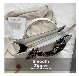 Détail de vue de dessus du sac cabas matelassé blanc avec zip et foulard en soie au manche