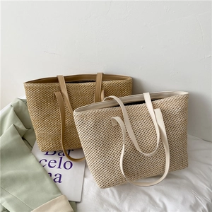 Minimalist woven straw tote bags in dark brown and beige with faux leather handles