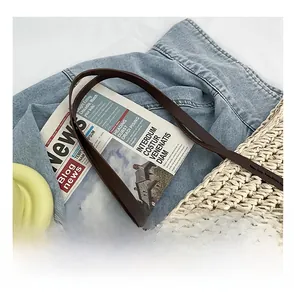Close-up of lightweight woven straw handbag with durable dark brown leather shoulder straps