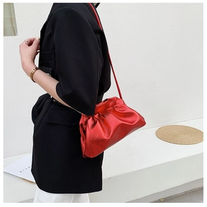 Gros plan du sac nuage rouge métallisé avec texture froncée et fine bandoulière