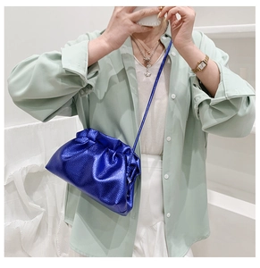 Détail du sac nuage bleu vif plissé avec finition métallique et texture cuir lychee