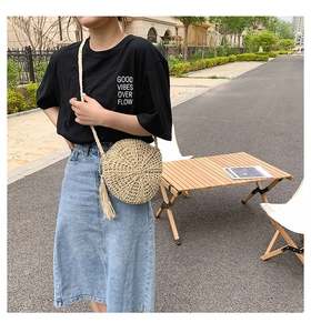 Detail of round straw bag with spiral texture and bohemian tassel for summer vacation