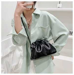 Détails du cuir grainé noir et des plis élégants sur un mini sac nuage en forme de dumpling