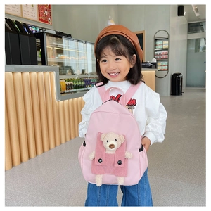 Dettaglio dello zaino rosa per bambini con orsetto di peluche 3D e tasca in velluto
