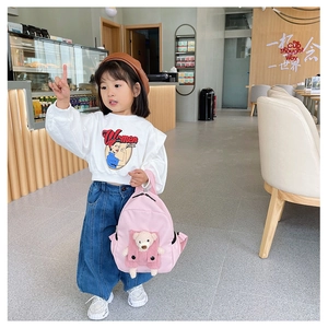 Dettaglio dello zaino rosa per bambini con orsetto di peluche e felpa con cappuccio