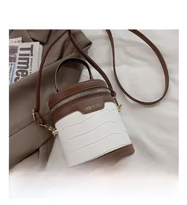 Detailansicht der zylindrischen Eimertasche mit Krokostruktur und Umhängeriemen