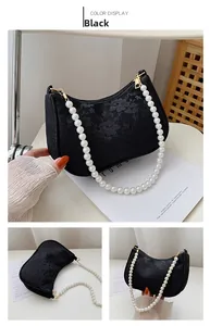 Detail of black floral lace crescent bag with elegant long pearl chain strap