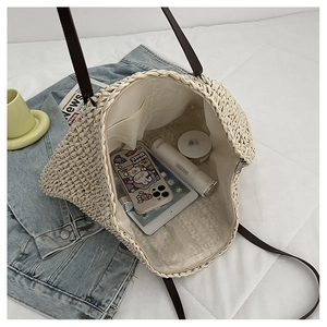 Interior view of large beige woven tote bag with brown straps showing spacious storage