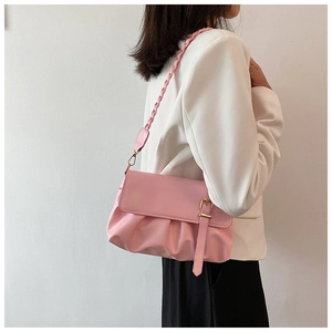 Close-up of pink pleated shoulder bag with gold buckle detail and braided strap