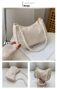 Detail of beige lace baguette bag with floral texture and elegant pearl shoulder strap