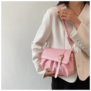 Detail of pink ruched leather shoulder bag with woven strap and gold buckle