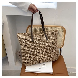 Macro shot of hand-woven straw tote texture with brown leather handles on a chair