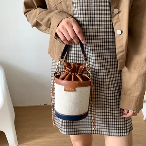 Minimalistische Beuteltasche aus Canvas mit Lederbesatz und Kordelzug in warmen Tönen