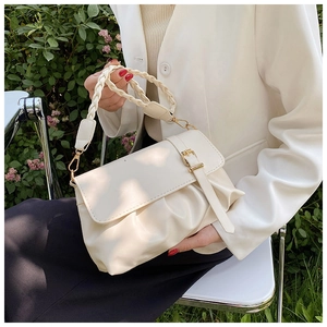 Detail of ruched creamy white PU leather bag with a woven handle and gold hardware buckle