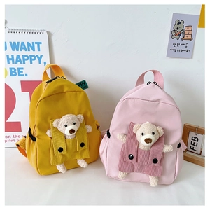 Dettaglio di zaini per bambini in tela colorata con teneri orsetti di peluche bianchi davanti