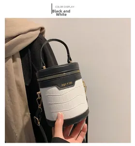 Detail einer Zylindertasche in Schwarz-Weiß mit Kontrastfarben und Krokodilmuster-Prägung