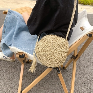 Bohemian beige round woven straw crossbody bag with tassel detail for women