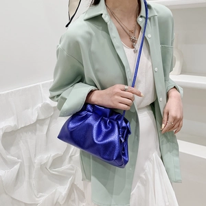 Sac nuage plissé bleu klein chic porté par un mannequin en tenue décontractée