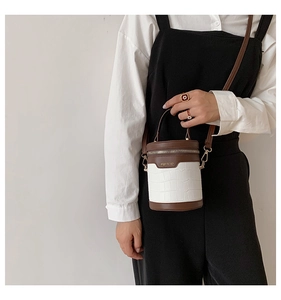 Model trägt eine Retro-Mini-Eimertasche mit Krokostruktur und braunem Schultergurt