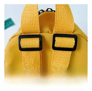 Dettaglio dello zaino giallo per bambini con spallacci in nylon regolabili e fibbie nere