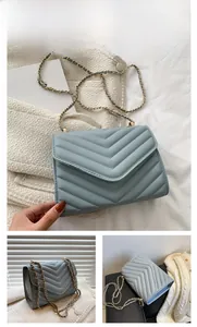 Detail of light blue crossbody bag with V-shaped quilting and golden chain strap