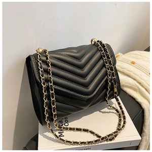 Close-up of black V-quilted leather crossbody bag with elegant gold chain strap detail