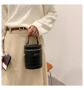 Details der schwarzen Zylindertasche mit Kroko-Prägung, Gold-Reißverschluss und Griff