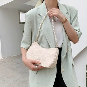 Elegant cream lace shoulder bag with large pearl strap and sleek gold zipper details