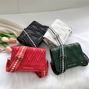 Quilted crossbody bags in four colors with wide patterned straps on white fabric