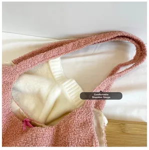 Détail d'un sac bandoulière rose en polaire avec bandoulière confortable et texture douce