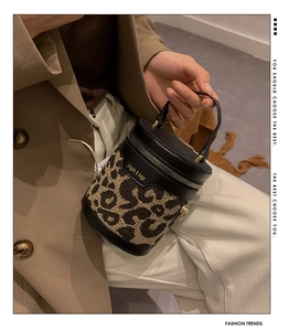 Close-up of leopard print bucket bag with black leather handle and zipper detail