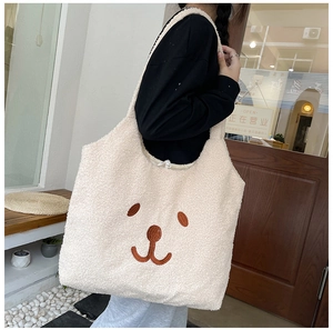 Détail du sac cabas en polaire beige avec texture pelucheuse et visage d'ours brodé marron