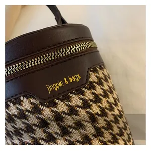 Close-up of premium leopard print barrel bag showing leather stitching and metal zipper