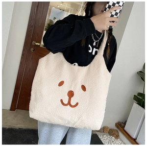 Détail du sac fourre-tout en polaire blanche avec broderie d'un petit ours brun