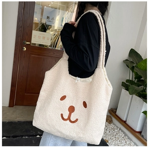 Détail du sac fourre-tout en peluche crème avec motif ours brodé et cordon de serrage