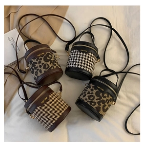 Detail of trendy mini bucket bags in leopard print and houndstooth patterns with gold hardware