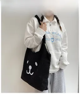Sac fourre-tout noir en peluche avec broderie ours porté par un mannequin au quotidien
