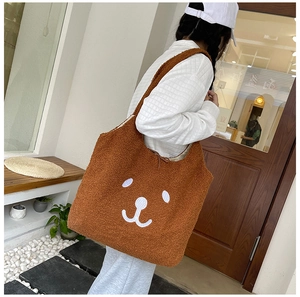 Vue détaillée du sac cabas marron en polaire teddy avec broderie visage d'ours blanc