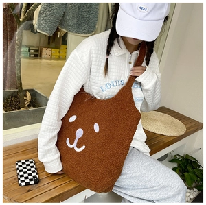 Gros plan d'un sac cabas en peluche marron avec broderie de visage d'ours blanc