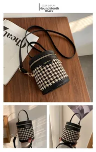 Detail of black houndstooth bucket bag with gold zipper and stylish shadow lighting