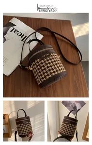 Detailed close-up of brown houndstooth barrel bag featuring leather trim and metal hardware