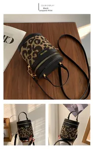 Close-up of leopard print bucket bag featuring gold hardware and black leather trim