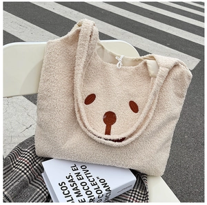 Détail d'un sac cabas en polaire peluche avec broderie ours sur une chaise pliante