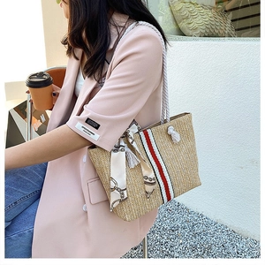 Straw beach tote bag with red stripes and silk scarf detail for summer travel