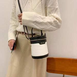 Modische Zylindertasche mit weißer Krokoprägung und schwarzem Leder im Kontrastdesign