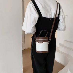 Borsa a secchiello cilindrica con motivo a coccodrillo e tracolla in pelle a contrasto