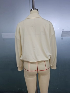 Detailed back view of a beige polo style long sleeve sweatshirt with ribbed cuffs and drop shoulder