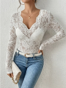 Dettaglio di body in pizzo floreale bianco con scollo a V ed eleganti bordi a smerlo